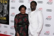 Damalie Namusoke smiling alongside her son, Oscar-winning actor Daniel Kaluuya, on the red carpet.