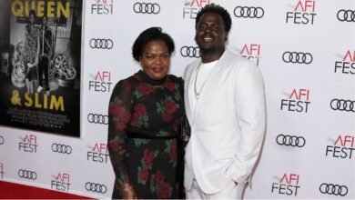 Damalie Namusoke smiling alongside her son, Oscar-winning actor Daniel Kaluuya, on the red carpet.
